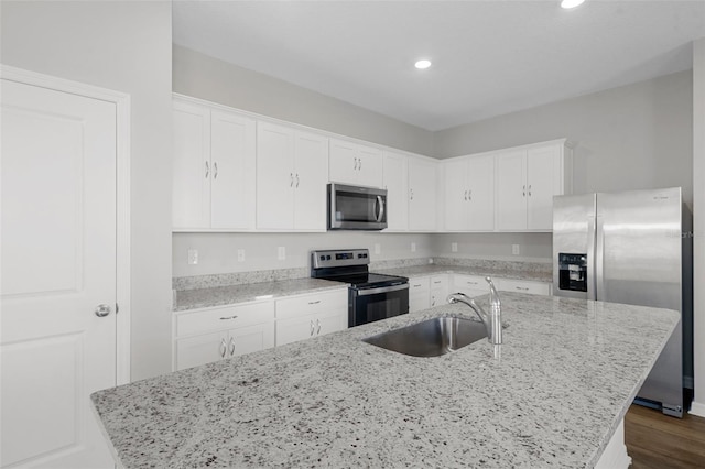 kitchen featuring a center island with sink, sink, white cabinetry, and stainless steel appliances