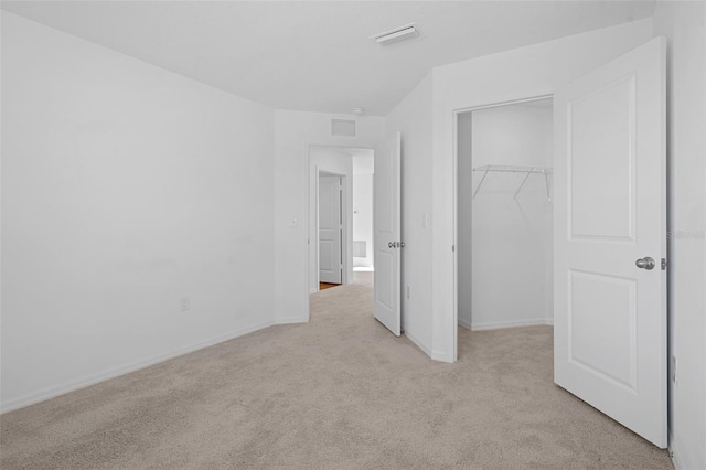 unfurnished bedroom with light carpet and a closet