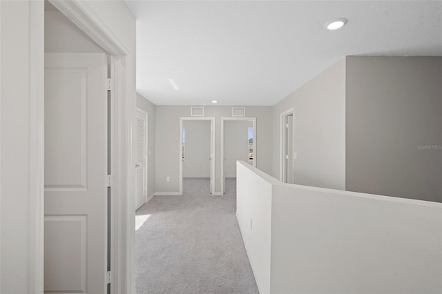 hallway featuring light colored carpet