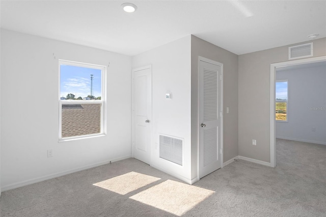 unfurnished bedroom featuring light colored carpet and a closet