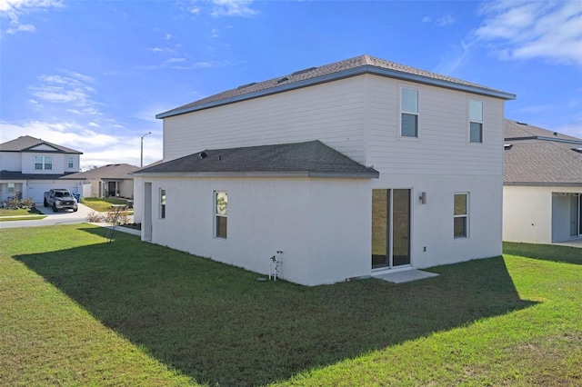 rear view of house featuring a lawn