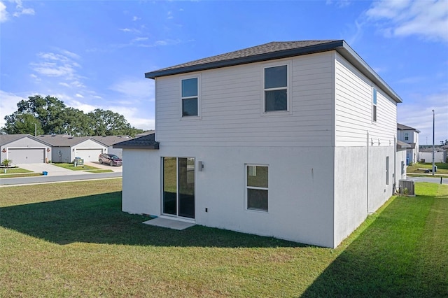 rear view of property with a lawn and cooling unit