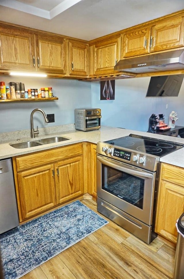 kitchen featuring open shelves, a sink, appliances with stainless steel finishes, under cabinet range hood, and light wood finished floors