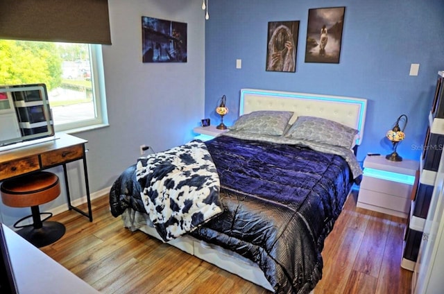 bedroom featuring baseboards and wood-type flooring