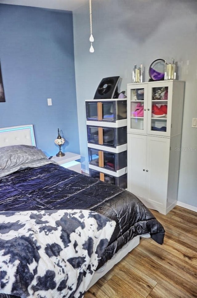 bedroom with baseboards and wood finished floors