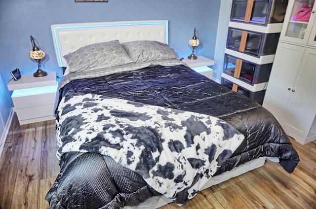 bedroom with baseboards and wood finished floors