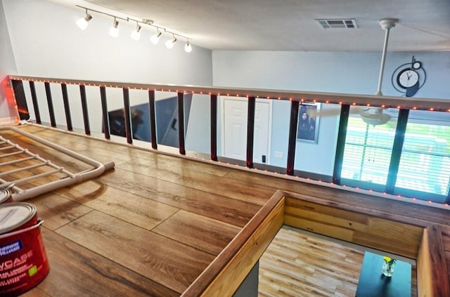 stairway featuring visible vents, wood finished floors, and track lighting