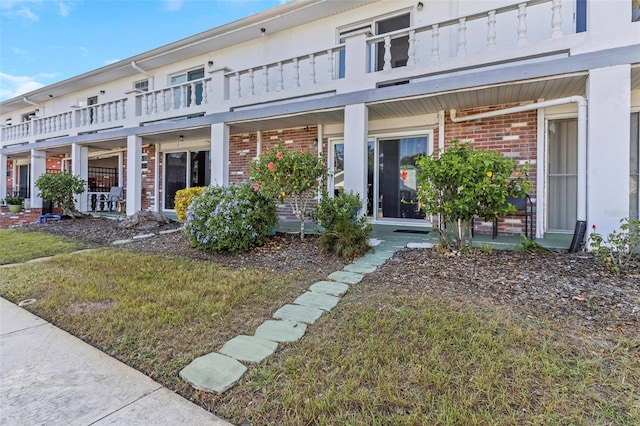 exterior space with a balcony and a front lawn