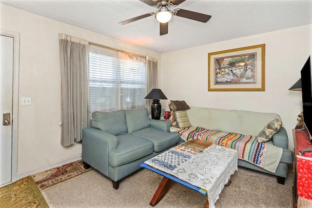 carpeted living room featuring ceiling fan and a textured ceiling