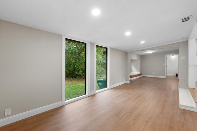 unfurnished room with crown molding, light hardwood / wood-style floors, and floor to ceiling windows