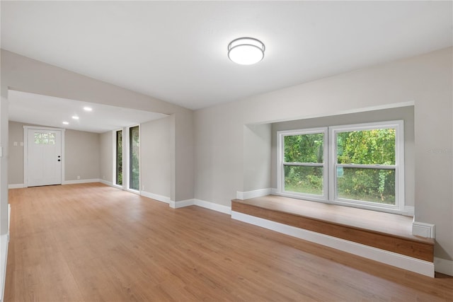 spare room featuring light hardwood / wood-style floors and vaulted ceiling