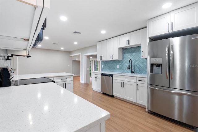 kitchen with sink, appliances with stainless steel finishes, light hardwood / wood-style floors, and white cabinets