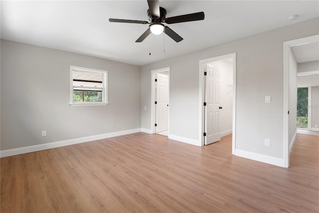 unfurnished bedroom with a spacious closet, light hardwood / wood-style floors, a closet, and ceiling fan