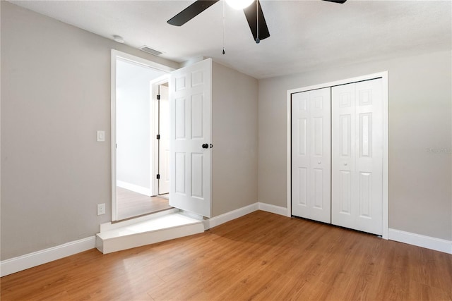 unfurnished bedroom with wood-type flooring, a closet, and ceiling fan