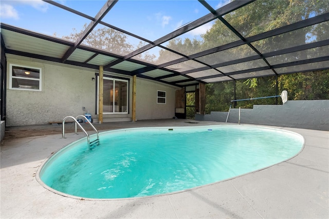 view of swimming pool with a patio area and glass enclosure