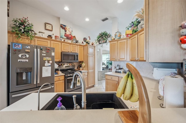 kitchen featuring light brown cabinetry, stainless steel appliances, light tile patterned floors, and tasteful backsplash