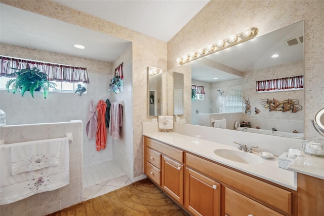 bathroom with vanity, a tile shower, and tile patterned floors