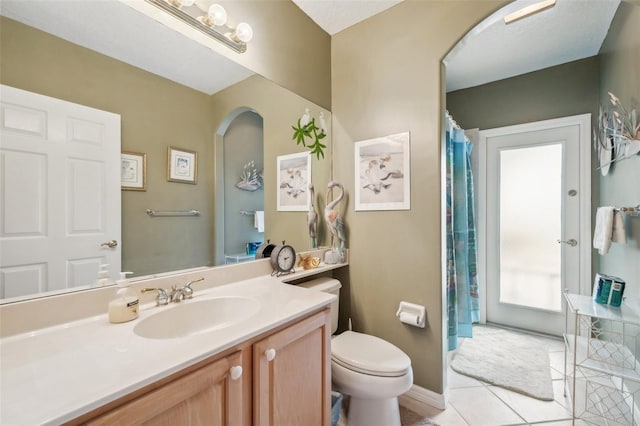 bathroom featuring toilet, vanity, and tile patterned flooring