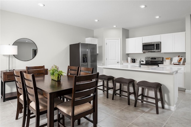 dining area featuring sink and light tile patterned floors