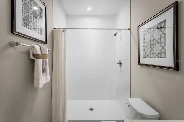 bathroom with toilet and a shower with curtain