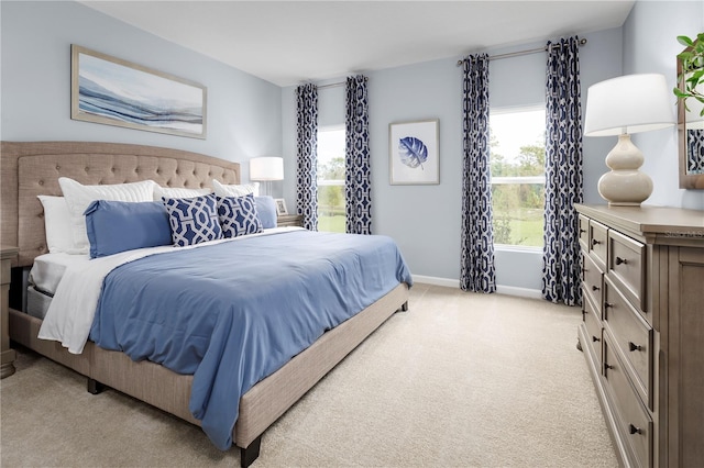 bedroom with light carpet and multiple windows