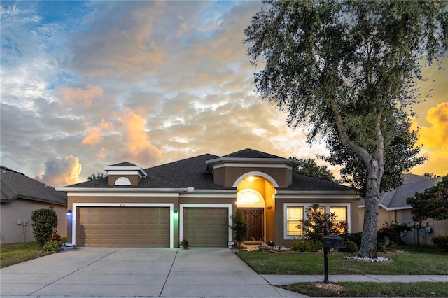 view of front of home featuring a garage and a lawn