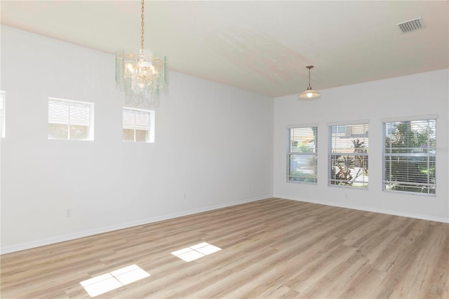 unfurnished dining area featuring a notable chandelier and light wood-type flooring