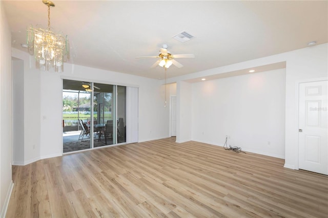 empty room with light hardwood / wood-style flooring and ceiling fan with notable chandelier