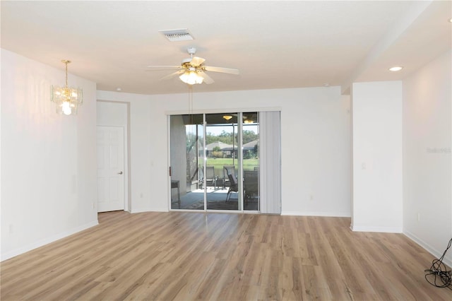 unfurnished room featuring ceiling fan with notable chandelier and light wood-type flooring