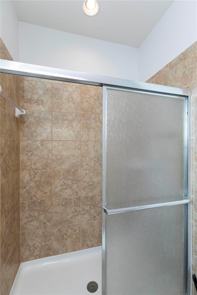 bathroom with a shower with door