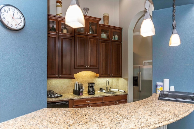 kitchen featuring dishwasher, sink, backsplash, stainless steel fridge, and decorative light fixtures