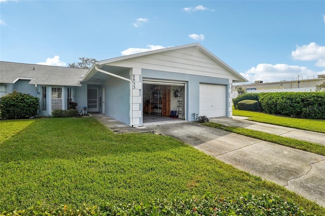 view of front of property featuring stucco siding, driveway, and a front yard