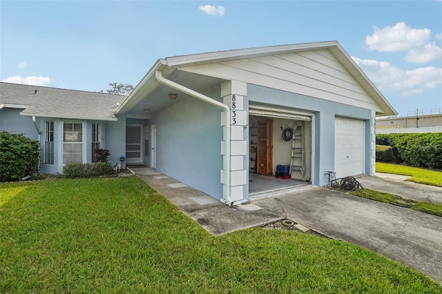 ranch-style home with a garage, a front yard, and stucco siding