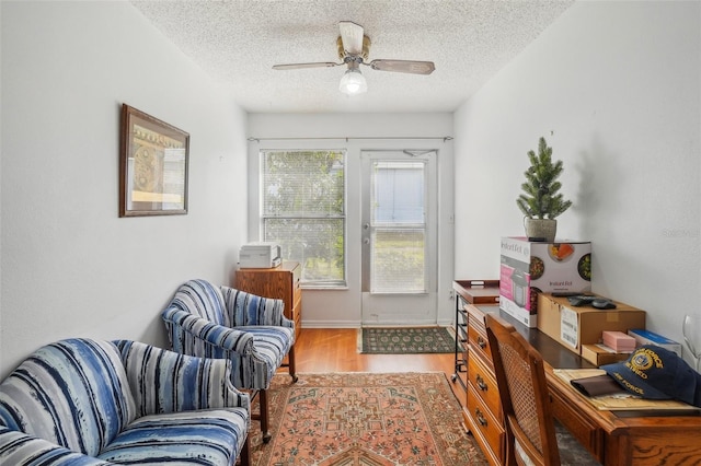 sitting room featuring a ceiling fan, a textured ceiling, and wood finished floors