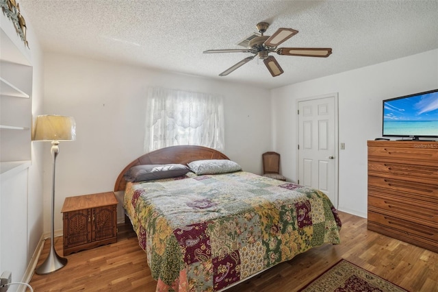 bedroom featuring a textured ceiling, a ceiling fan, and wood finished floors