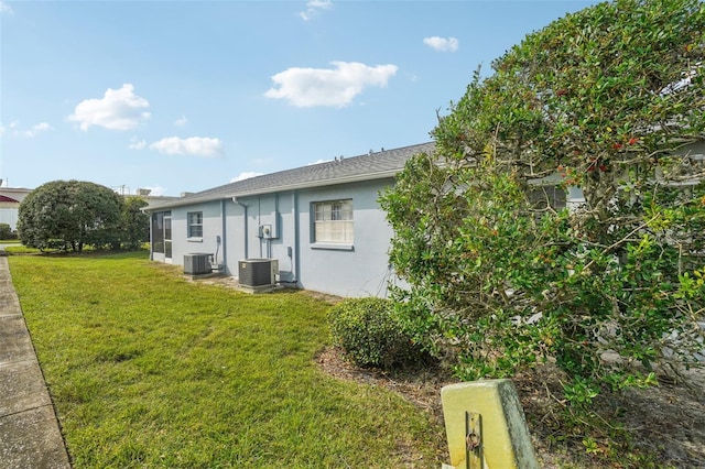 back of property with a yard, stucco siding, and cooling unit