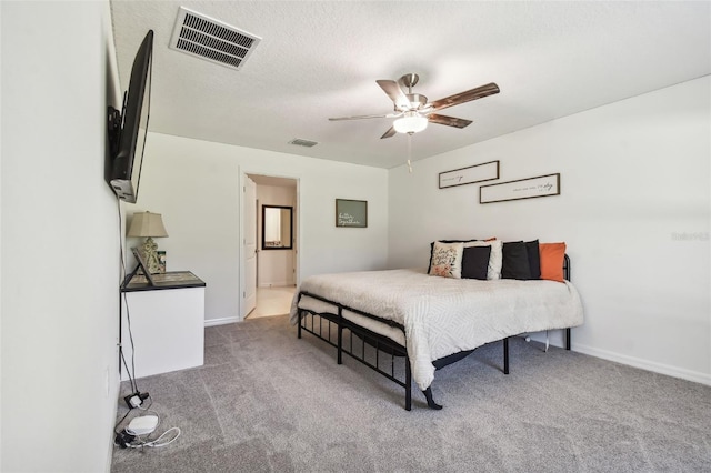 carpeted bedroom featuring a textured ceiling, ceiling fan, and ensuite bathroom