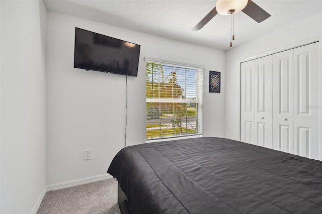 carpeted bedroom with ceiling fan and a closet