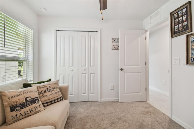 sitting room with light colored carpet and ceiling fan