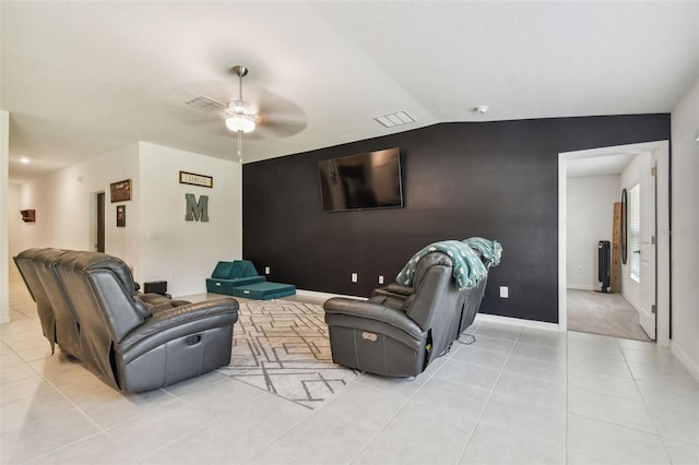 living room featuring lofted ceiling, light tile patterned floors, and ceiling fan