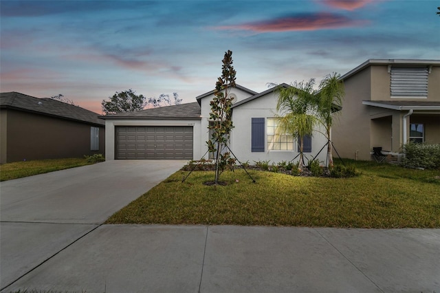 ranch-style home with a garage and a lawn