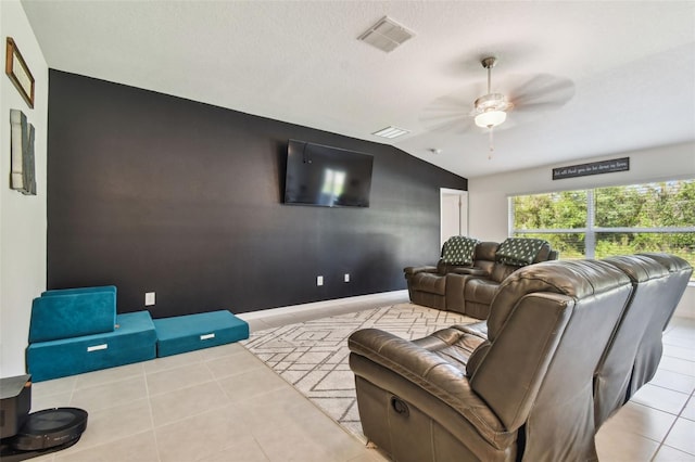 tiled home theater room featuring ceiling fan and vaulted ceiling