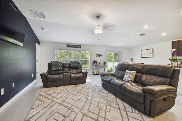 tiled living room with a textured ceiling and ceiling fan