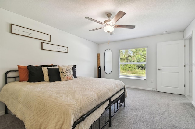 carpeted bedroom with a textured ceiling and ceiling fan