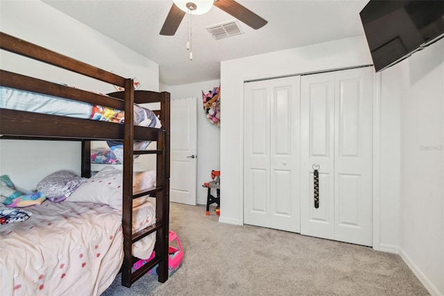 bedroom featuring ceiling fan, a closet, and light colored carpet