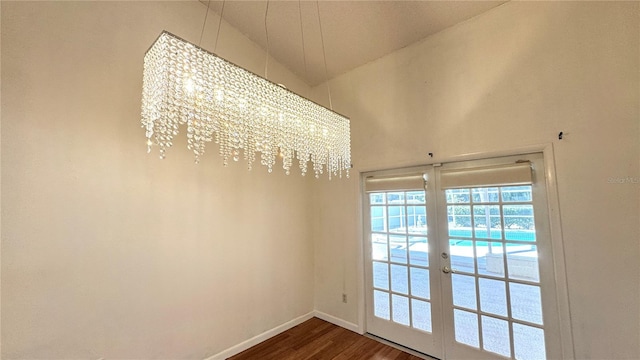 entryway featuring a chandelier, french doors, wood-type flooring, and vaulted ceiling