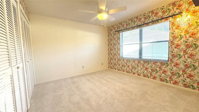 unfurnished bedroom with a textured ceiling, ceiling fan, light carpet, and a closet