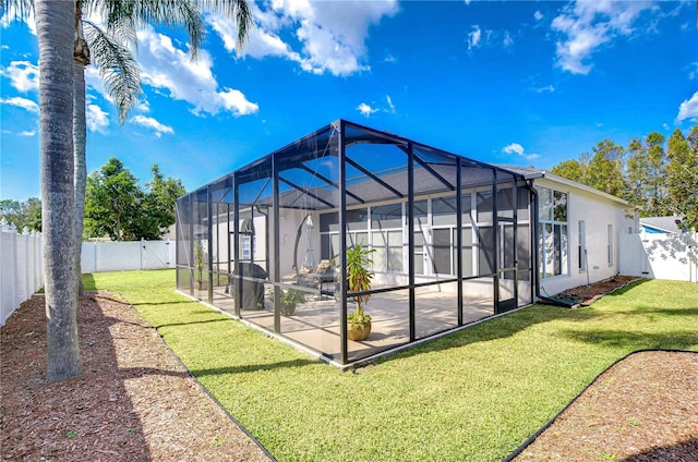 rear view of house featuring a patio, a lanai, and a yard