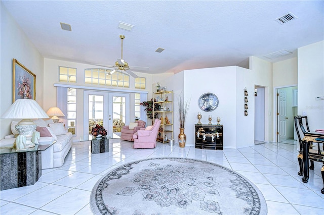 living room featuring french doors, ceiling fan, a textured ceiling, and light tile patterned floors