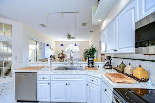 kitchen with white cabinets, stainless steel appliances, sink, and a wealth of natural light